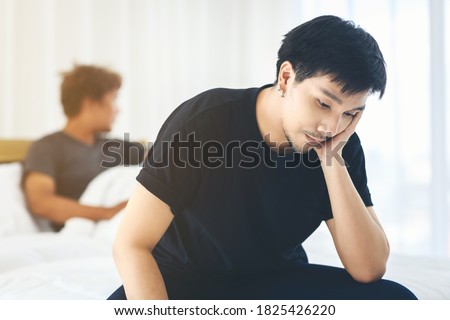 A man in a black T-shirt is sitting in distress with his lover.