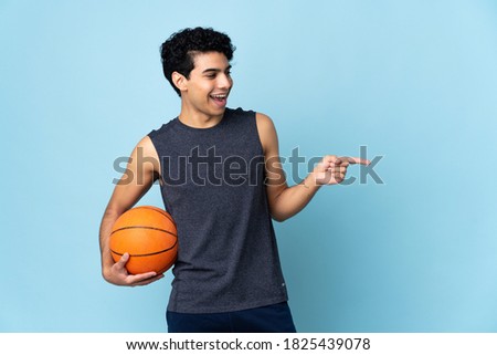 Venezuelan basketball player man over isolated background pointing finger to the side and presenting a product