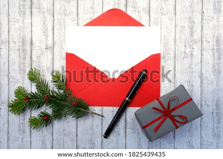 Christmas background concept with card blank, red envelope, gift gray, branch green, white wood, ink pen, decoration.