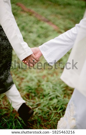 Malay wedding. One of the outdoor photography sessions.  The picture shows when holding hands and also leading hands between the bride and groom.