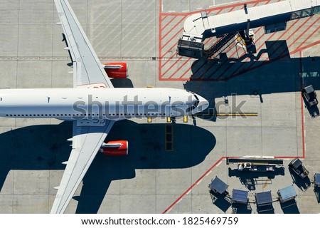 Aerial view of airport. Airplane is taxiing to gate of terminal. Royalty-Free Stock Photo #1825469759