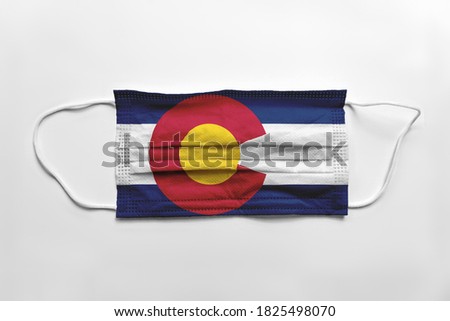 Face mask with Colorado flag printed, on white background, isolated safety concept