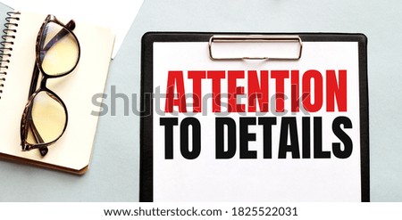 Business concept. Notebook with text ATTENTION TO DETAILS sheet of white paper for notes, glasses in the white background