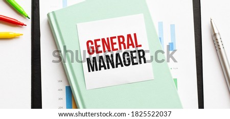 Financial diagram on white big notepad, green book and paper sheet with text GENERAL MANAGER. Business concept