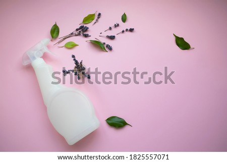 Plastic bottle with liquid for washing glass, plumbing, tiles or floor and lavender sprigs on a pink background with space for text. Natural organic cleaning product. Eco-concept. Poster. Royalty-Free Stock Photo #1825557071
