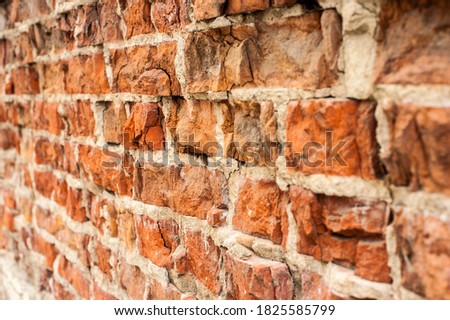 Old brick wall with crumbling stones close-up