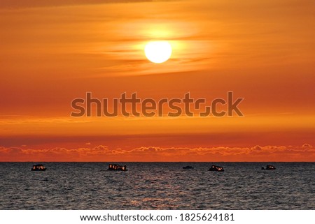 The outlines of the boats against the background of the sea sunset.