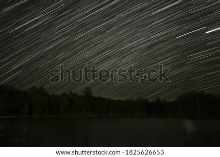 Star trails at night otter lake in summer Michigan upper peninsular