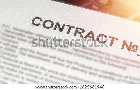 A business contract printed on a white sheet of paper and a light in the corner.