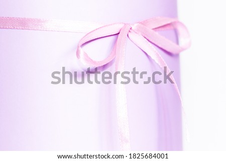 Festive purple box with a bow on the table. Content for congratulations. partial focus