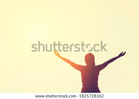 Copy space of silhouette woman raise hand up on top of mountain and sunset sky cloud abstract background. Freedom feel good and travel adventure holiday concept. Vintage tone filter effect color style