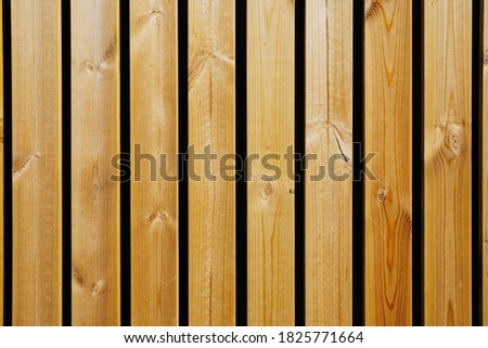 The texture of wooden boards close-up in an upright position on a black background.