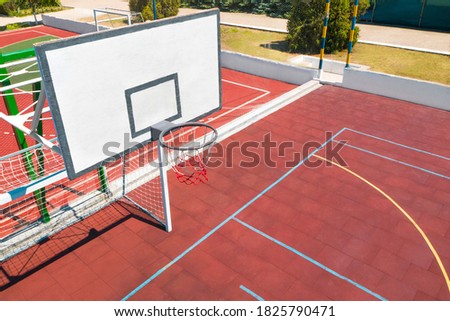 Basketball backboard over football gat at outdoor sports complex on sunny day