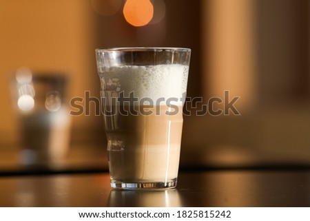 Close up view of a glass of latte macchiato coffee drink in warm sunset light
