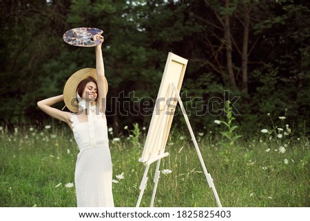 Woman artist with easel palette in hands on art nature