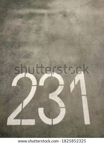 Numbers/numerals painted on the floor of an indoor carpark slot.