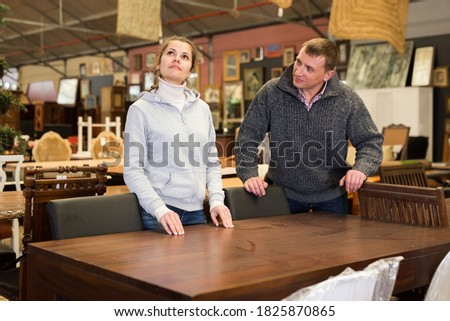 Couple chooses table in furniture store. High quality photo