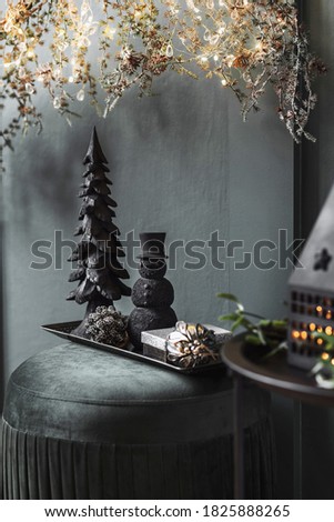 Christmas composition on the green velvet pouf in living room. Beautiful decoration. Christmas trees, candles, stars, lights and elegant accessories. Merry Christmas and Happy Holidays, Template. 