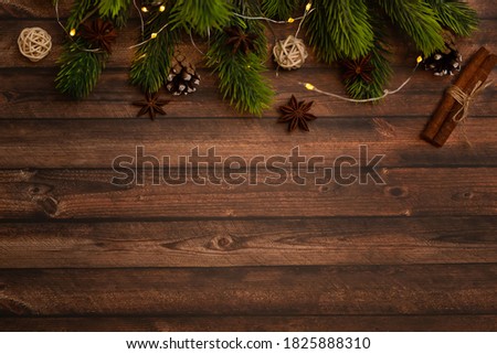 Christmas tree branches with decorations on a wooden wall background. Template for greeting card or design. Horizontal banner with copy space