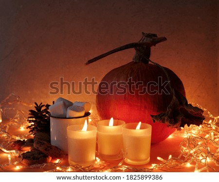 View of  a halloween pumpkin with some candles and lights on the background
October background.