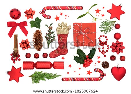 Christmas composition with red bauble decorations, winter holly, ivy, mistletoe, fir & gift related symbols on white background. Xmas theme for the festive season. Flat lay, top view.