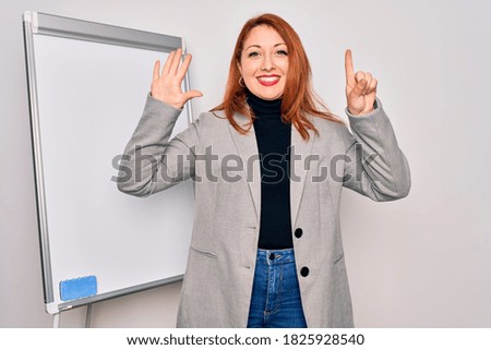 Young beautiful redhead businesswoman doing business presentation using magnetic board showing and pointing up with fingers number six while smiling confident and happy.
