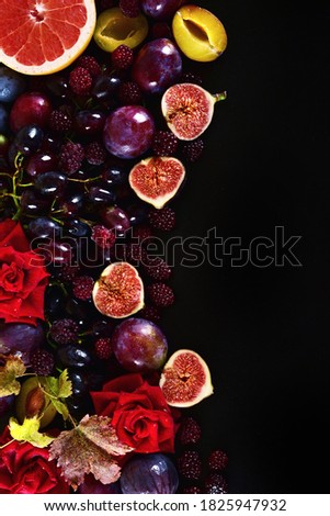 Autumn background still life of multicolored fruits and flowers on a black background. Place for text
 
