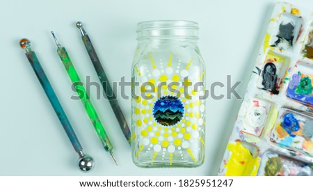Clear glass bottle dot mandala painting with equipment and colour palate 