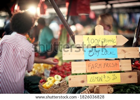 Sign for fresh and organic vegetables and fruits at the green market or farmers market stall.  Young buyers choose and buy products for healthy food in grocery. All for diet healthy eating, lifestyle.