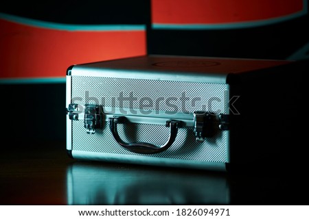 silver fluted microphone case on black and red background