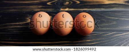 the German word BIO which means in English ORGANIC stamped on three eggs on wooden surface, web banner size