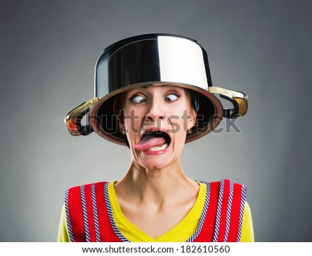 Crazy housewife with sause pan on her head Royalty-Free Stock Photo #182610560