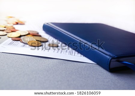 Business notepad with business documents and coins on the table. Business concept.