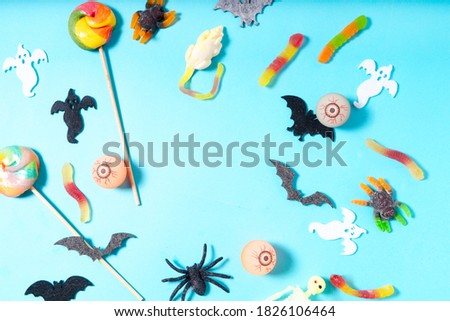 Halloween flat lay top view frame with candies on aqua blue background