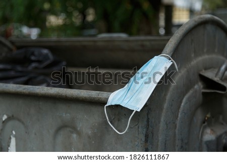 A used coronavirus mask lies on a trash can. Mask for protection against covid-19. Consequences of covid-19.  Royalty-Free Stock Photo #1826111867