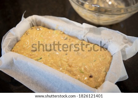 Courgette zucchini loaf cake mixture in a tin (before baking) Royalty-Free Stock Photo #1826121401