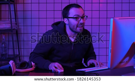 Gamer playing a game very excited and commenting on the game. Royalty-Free Stock Photo #1826145353