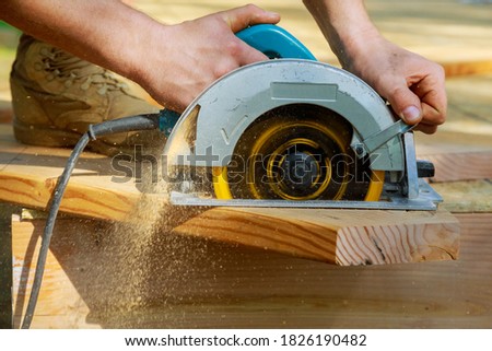 Carpenter using circular saw for wood beam a new home constructiion project Royalty-Free Stock Photo #1826190482
