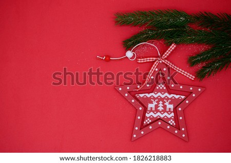 Red Christmas stars and a green branch of the Christmas tree on a red background. Christmas flatly. New year 2021.