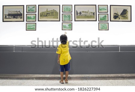 Little girl staring at the beauty in the pictures.