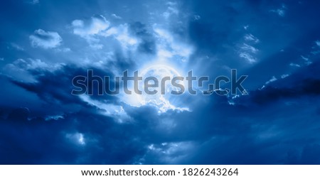Night sky with moon in the clouds, dark sea in the foreground "Elements of this image furnished by NASA
