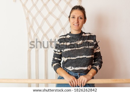 young Spanish girl enjoying in front of handmade macrame curtain with white background