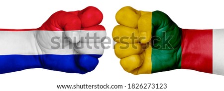 The concept of the struggle of peoples. Two hands are clenched into fists and are located opposite each other. Hands painted in the colors of the flags of the countries. France vs Lithuania