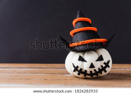 Funny Halloween day party concept ghost pumpkins head jack lantern scary smile wear hat on wooden table and black background, studio shot isolated, Holiday decoration