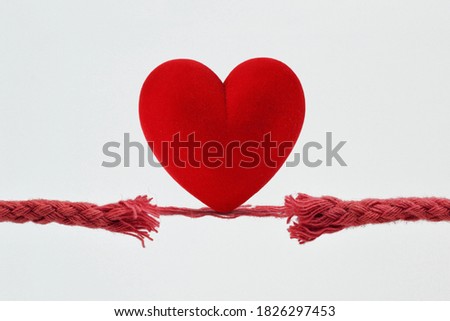 Heart on nearly broken rope - Concept of love and risk Royalty-Free Stock Photo #1826297453