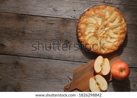 Traditional homemade apple pie with fresh apples on wooden table. Copy spce. Top view.
