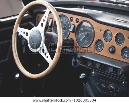The steering wheel and dashboard of an antique classic car.