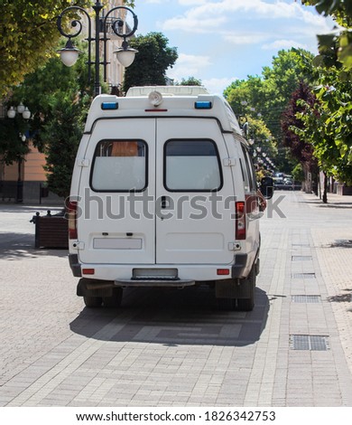 Ambulance on City Street in Summer Day