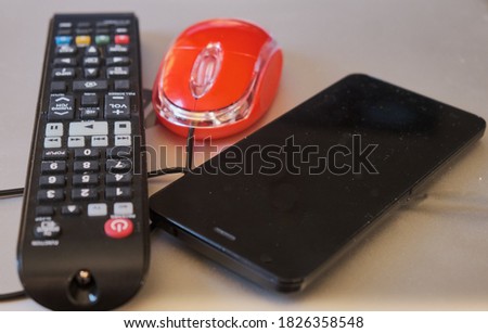 Close-up of a mobile computer mouse and a tv remote