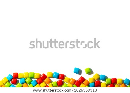 Color candy on the bottom on white background top view frame. Chewing gum, and dragees are scattered. Space for text